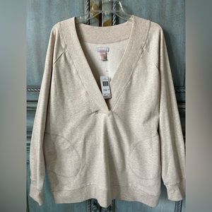 This top is a poly/cotton blend (68% cotton) with a v neck &  big side pockets.